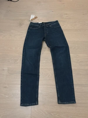 Mörkblå jeans från Jack & Jones - Riktigt schyssta mörkblå Jack and Jones jeans som är helt sprillansnya. Säljer dessa då de inte passar mig. Skick 10/10. Storlek 32x34