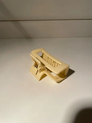 Ny Ljusgul Léonie Hårklämma - En superfin Hårklämma i matt gul färg som ger en extra touch till outfiten i storlek Small! Kvaliteten är fantastisk och den ska sitta hela dagen utan problem⭐️😊