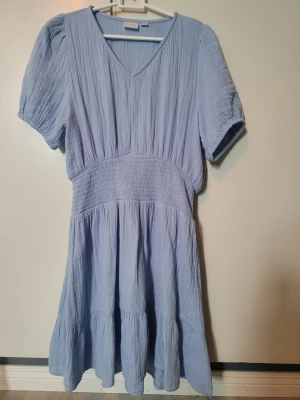 3 barnklänningar till sommar och fest - 1. Supersöt ljusblå klänning i bomull  från Gina Tricot med v-ringning och korta puffärmar stl 158 . 2. Cool klänning i polyester, men underkjol i turkost stl 146. 3. Fin-dress skjorta och blus i ett, ärmlös med söt vilan upp över axlarna stl 158. 80kr st eller 160 för alla 3.