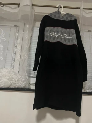 Black Hoodie Dress - Stylish black hoodie dress from My Own. Features a grey patterned panel on the chest and hood with subtle embroidered logo detail. Long sleeves, comfortable fit and soft fabric – perfect for everyday wear, casual outfits or layering. ✔ Size: EU 38 ✔ Color: Black & grey ✔ Condition: Very good, no visible flaws ✔ Style: Casual / streetwear / sporty chic Comfortable and easy to style with sneakers or boots. Great for autumn and winter. Feel free to message me if you have questions 🌸 