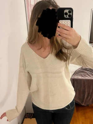 Beige stickad tröja från ONLY - Beige stickad tröja från ONLY med v-ringning och långa ärmar. Perfekt för lager-på-lager och passar till allt. Tröjan är i XS men skulle säga att den passar XS - M!🩷