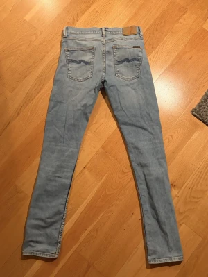 Ljusblå y jeans från Nudie - Säljer ett par ljusblå  jeans från Nudie Jeans. Lean Dean i 30:34.