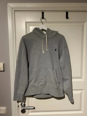 Grå hoodie från Polo Ralph Lauren - Säljer en Grå hoodie från Polo Ralph Lauren i storlek Medium.  Använd ett få antal gånger, skick 9/10. Nypris 2295 hör av ifall det är funderingar.