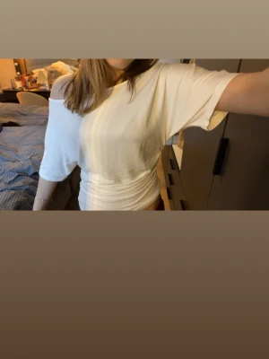 Vit offshoulder topp med rynk - Säljer en vit offshoulder topp med rynkdetaljer i midjan. Toppen har korta ärmar och en lösare passform upptill, vilket ger en avslappnad men ändå trendig look. Helt nyskick ❤️
