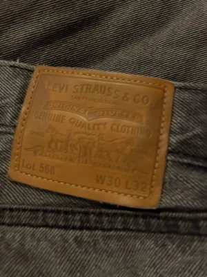 Levi's 568 grå jeans straight fit - Grå jeans från Levi's modell 568 med klassisk rak passform och fem fickor. Jeansen har en snygg tvättad look och är tillverkade i slitstarkt bomullsmaterial. Perfekta för dig som gillar en enkel och tidlös stil.
