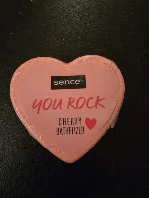 Sence Cherry Bathfizzer hjärta - Söt badbomb från Sence i form av ett rosa hjärta med texten 'You Rock'. Doft av körsbär som gör badet extra lyxigt och fräscht. Perfekt för dig som vill ha en rolig och väldoftande badupplevelse.