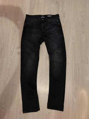 Replay Grover svarta straight jeans - Aldirg andvända. Ångrade mig vid köp. Säljer ett par svarta Replay Grover jeans med straight fit. Klassisk femficksmodell med snygga detaljer och metallnitar. Jeansen är tillverkade i ett mjukt och slitstarkt bomullsmaterial och har en diskret tvättad look. Perfekta för dig som gillar stilrena svarta jeans.