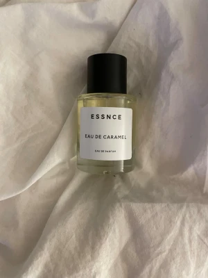 ESSNCE Eau de Caramel parfym - ESSNCE Eau de Caramel är en Eau de Parfum i en stilren, rund glasflaska med svart lock. Doften har en söt karamellton  Perfekt för dig som gillar gourmanddofter och vill ha något unikt i parfymhyllan. 50 ML Aldrig använd kände att doften ej var min smak
