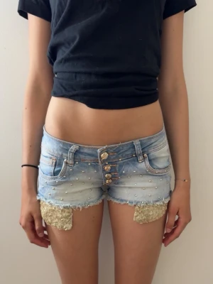 lågmidjade shorts - säljer mina supersnygga vintage shorts med guldiga fickor och gulda nitar! Perfekt till fester och  sommaren.💕 Midjemått: 36cm och passar som XS!