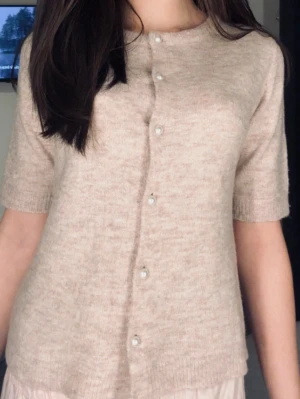 Beige stickad tröja från Lager 157 - Beige stickad tröja från Lager 157  Superfin och mysig stickad tröja i en neutral beige färg 🤍 Perfekt till vardags eller att styla upp med kjol/jeans.  ▫️ Storlek: XS ▫️ Skick: Bra, OBS sista knappen längst ner är trasig (syns knappt och går lätt att laga) ▫️ Kortärmad – perfekt för vår/sommar eller över en topp  Skriv vid frågor eller för fler bilder! 💌  