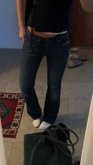 Mörkblå bootcut jeans från Levi's - Säljer ett par mörkblå Levi's jeans med klassisk bootcut passform och låg midja. Jeansen har fem fickor, knappgylf och är tillverkade i slitstarkt denimtyg. Perfekta för en avslappnad och snygg look.