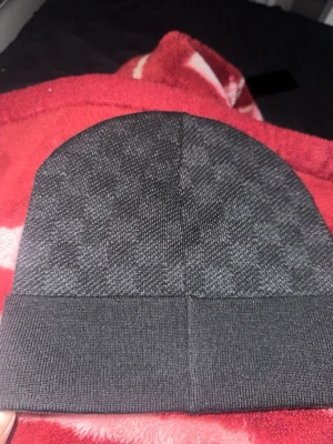 Svart enkel mössa med uppvikt kant - Säljer en stilren svart mössa med uppvikt kant. Mössan har en diskret textur och är tillverkad i ett mjukt, stretchigt material som sitter skönt på huvudet. Perfekt för dig som gillar en clean och enkel look.