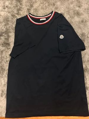Mörkblå Moncler t-shirt - Snygg mörkblå t-shirt från Moncler. Den är som ny inga skador eller slitningar väldigt fin i färgen och är av bra material. 
