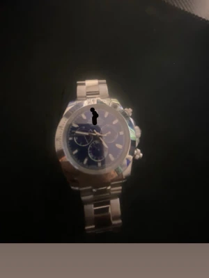 Stilrent r klocka  - Säljer en snygg klocka i rostfritt stål med silverfärgad länk och blå urtavla. Klockan har kronograffunktion och tydliga indexmarkeringar. Perfekt accessoar för dig som gillar en sportig men ändå klassisk look.