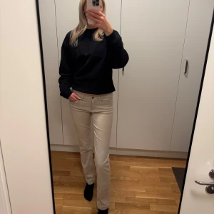 Low Waist Jeans - Beiga low waist jeans med raka ben, fina detaljer på bakfickorna. Rätt långa i benen! Lite små skavanker i färgen på byxorna (borde gå bort efter tvätt)