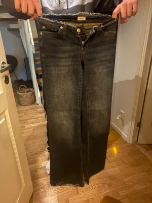 Jeans från Nelly i mörkblå  - Knappt använda mörkblåa boot cut/ low waist jeans från Nelly i storlek 32 