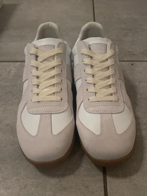 Maison margiela Gats - Maison Margiela Gats i vit och beige. Storlek 43 Nyskick. Skadad box. Priset kan diskuteras vid snabb affär.