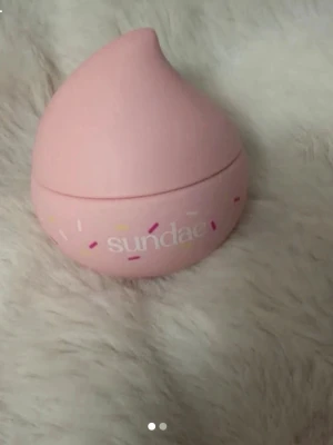 Sundae body whip - Söt rosa burk från Sundae med droppformad design och dekorativa strösseltryck. Burken är tillverkad i plast och har ett skruvlock. Body lotion i doften birthday cake endast testad och helt ny. Köpte för 339kr kom med prisförslag