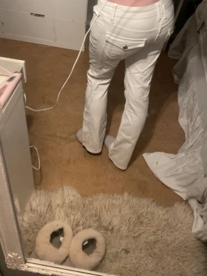 Vita bootcut jeans från Gina Tricot - Säljer ett par vita jeans från Gina Tricot med bootcut passform. Jeansen har klassiska fickor både fram och bak, samt bälteshällor och dragkedja med knapp. Perfekta för dig som vill ha en clean och fräsch look.