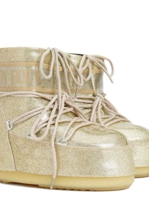 Glittriga guld Moon Boots - Säljer ett par glittriga guldiga Moon Boots med snörning. Bootsens yta är täckt av glittrigt material och de har en rejäl platt sula. Perfekta för vintern när du vill sticka ut och hålla värmen.