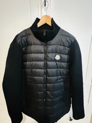 Svart dunjacka från Moncler - Jag säljer min moncler cardigan som jag har  använt i ett år. Bra kvalitet på den och logan  scannar in i moncler.com. Obs tyvärr är den inte  riktigt vilket är varför jag säljer den billigt. Om du  vill ha mer bilder så fråga bara.