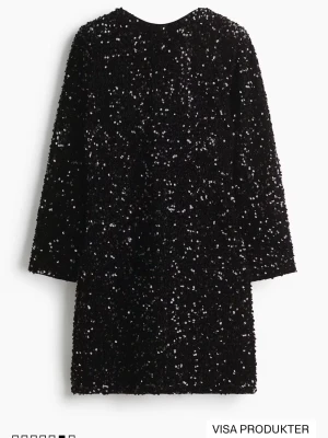 Svart paljettklänning med lång ärm - Glittrig svart klänning täckt med paljetter, har lång ärm och rak passform. Perfekt för dig som vill sticka ut och glänsa på nästa event. Klänningen är kort och har en klassisk rund halsringning. Aldrig använd har även prislappen på. Passar S-L