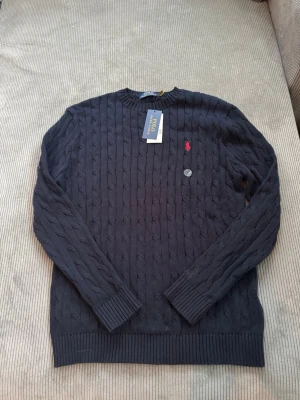  Ralph Lauren cable hoodie - Säljer min Ralph Lauren cable stickad hoodie eftersom den är för liten och var ej tillgänglig att lämna tillbaka Den är helt ny, bara testad på. Storlek M. Passar 170-180 beroende på vikt och överkropps storlek!