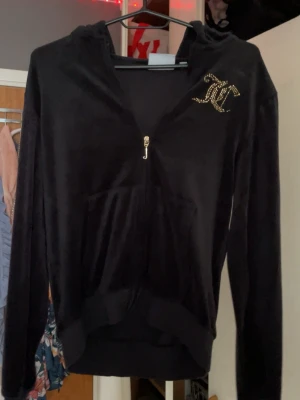 Svart velour hoodie Juicy Couture - Snygg svart velour hoodie från Juicy Couture men tyvärr lite slitningar på ryggen 