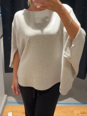 Beige oversized tröja - Säljer en beige oversized stickad tröja med vida trekvartsärmar och rund hals. Tröjan har en avslappnad passform och är supermjuk, perfekt för lager-på-lager och chill dagar. Enkel och stilren design som är lätt att matcha. Har ej kommit till använding!