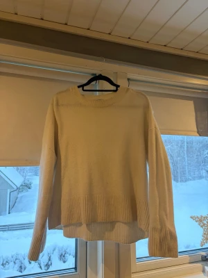 Vit stickad tröja från & Other Stories - Mysig vit stickad tröja från & Other Stories Paris Atelier. Tröjan har rund hals, långa ärmar och bred ribbad kant nedtill och vid ärmsluten. Köpt för omkring 500kr. Passar mig som vanligtvis har S-M.