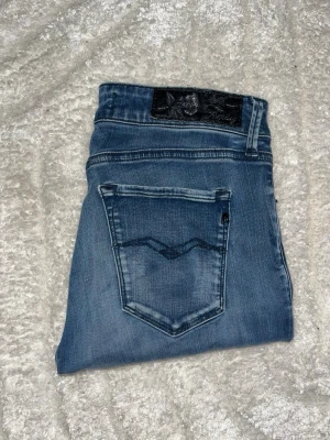 Replay jeans - Säljer ett par snygga Replay jeans i blå tvätt med skinny fit. Midja 35cm, längd 97cm.JAG SKICKAR EJ FLER BILDER NÄR JAG BÄR JEANSEN! för bättre inblick i passformen rekommenderar jag att googla på modellnamnet. För storleksguide kolla måtten noggrant då jeansen alltid kan vara uppsydda heller krympta och jag ej tar emot returer :) s6,1