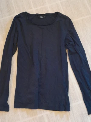 Mörkblå långärmad topp Kappahl - En enkel och stilren mörkblå långärmad topp från Kappahl. Toppen har rund halsringning och är gjord i mjukt bomullsmaterial. Perfekt att matcha med jeans eller kjol för en clean look. !!endast swish +frakt!!