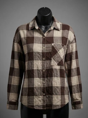 Brun och beige rutig skjorta  - Säljer en rutig skjorta i bruna och beige toner med klassisk krage och knappstängning framtill. Skjortan har en bröstficka och långa ärmar. Perfekt för dig som gillar avslappnad stil och jordnära färger.