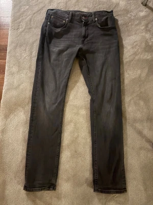 Grå Tommy hilfiger jeans - Säljer ett par svarta jeans från Tommy Hilfiger i straight fit. Nypris 1200kr, raka ben och är tillverkade i stretchigt jeanstyg för extra komfort. Perfekta för dig som gillar en enkel och stilren look. 9/10 skick och försiktigt använd. Skriv om funderingar 🙏🤩