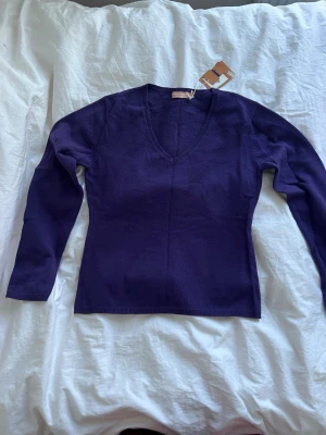 Lila kashmirtröja från El Corte Inglés - Oanvänd supersnygg lila tröja i 100% kashmir från El Corte Inglés. Tröjan har v-ringning och långa ärmar, perfekt för dig som vill ha något mjukt och lyxigt i garderoben. Enkel och stilren design som är lätt att matcha.