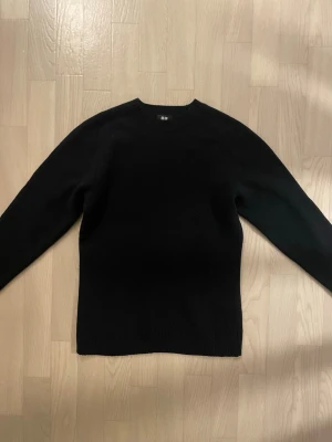 Lambswool Knit : Uniqlo - Klassisk svart tröja från Uniqlo i 100% ull. Enkel och stilren design med rund hals och långa ärmar. Perfekt att slänga på sig när det är kyligt ute och funkar till allt i garderoben, varken om du är ute efter archive, starboy eller en grisch look. Skulle säga att den passar lite mindre än en S, därav jag annonserar den som en XS.  🐕❌ Djurfritt hem 🌿❌ Rökfritt hem  Originalpris: 500 SEK