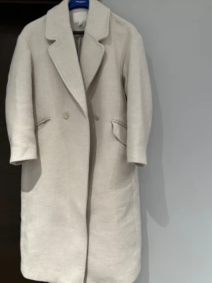 Beige ullkappa med knappar - Snygg beige kappa i ullmix med klassisk krage och dubbelknäppning framtill. Kappan är i Oversize modell och passar från xs upp till storlek L💕väldigt fin och elegant! Använd 4-5 gånger max därav som ny💕💕