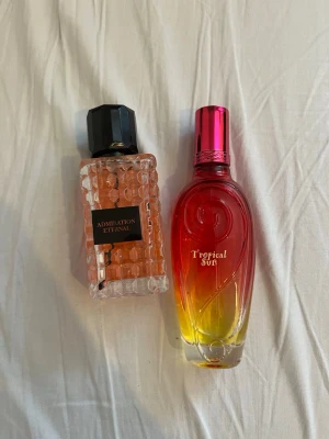 Admiration Eternal & Tropical Sun - Två parfymer: Admiration Eternal med elegant design och Tropical Sun i färgstark flaska. Perfekt för dig som vill sticka ut och testa nya dofter. Volym och ingredienser syns ej på bilden. Båda för 100kr 