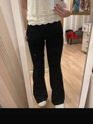 Svarta bootcut byxor från Nelly - Säljer ett par svarta bootcut byxor från Nelly i storlek 32. Byxorna har en klassisk midja, raka ben som blir vidare nedtill och stängs med dragkedja och knapp. Materialet är mjukt och stretchigt, vilket gör dem riktigt sköna att bära.