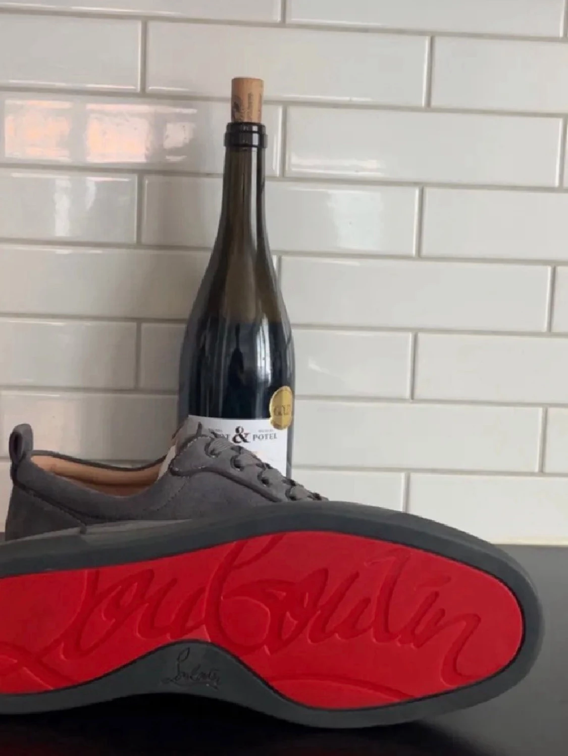 Gråa Louboutin sneakers med röd sula