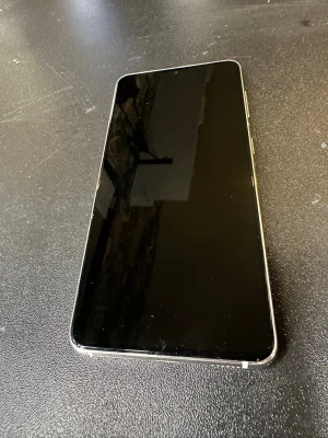 Samsung Galaxy S21 - Samsung Galaxy S21 i vit. Telefonen har trippelkamera, USB-C-port. Skärmen ser hel ut utan synliga sprickor. Perfekt för dig som söker en kraftfull Android-telefon till ett bra pris.