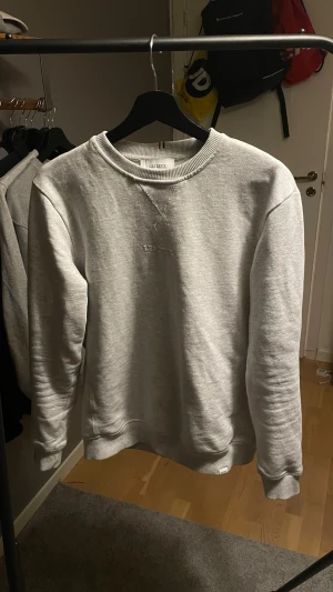 Ljusgrå Les Deux - Säljer en stilren ljusgrå sweatshirt från Les Deux i storlek XS. Tröjan har  Les Deux-logga på bröstet. Perfekt basplagg till garderoben och riktigt skön att bära. nypris 839kr