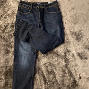 Mörkblå jeans straight fit - Snygga mörkblå jeans från Blend med klassisk femficksdesign och kontrastsömmar. Jeansen har rak passform och är tillverkade i slitstarkt denimtyg. Perfekta för dig som gillar en enkel och tidlös look.
