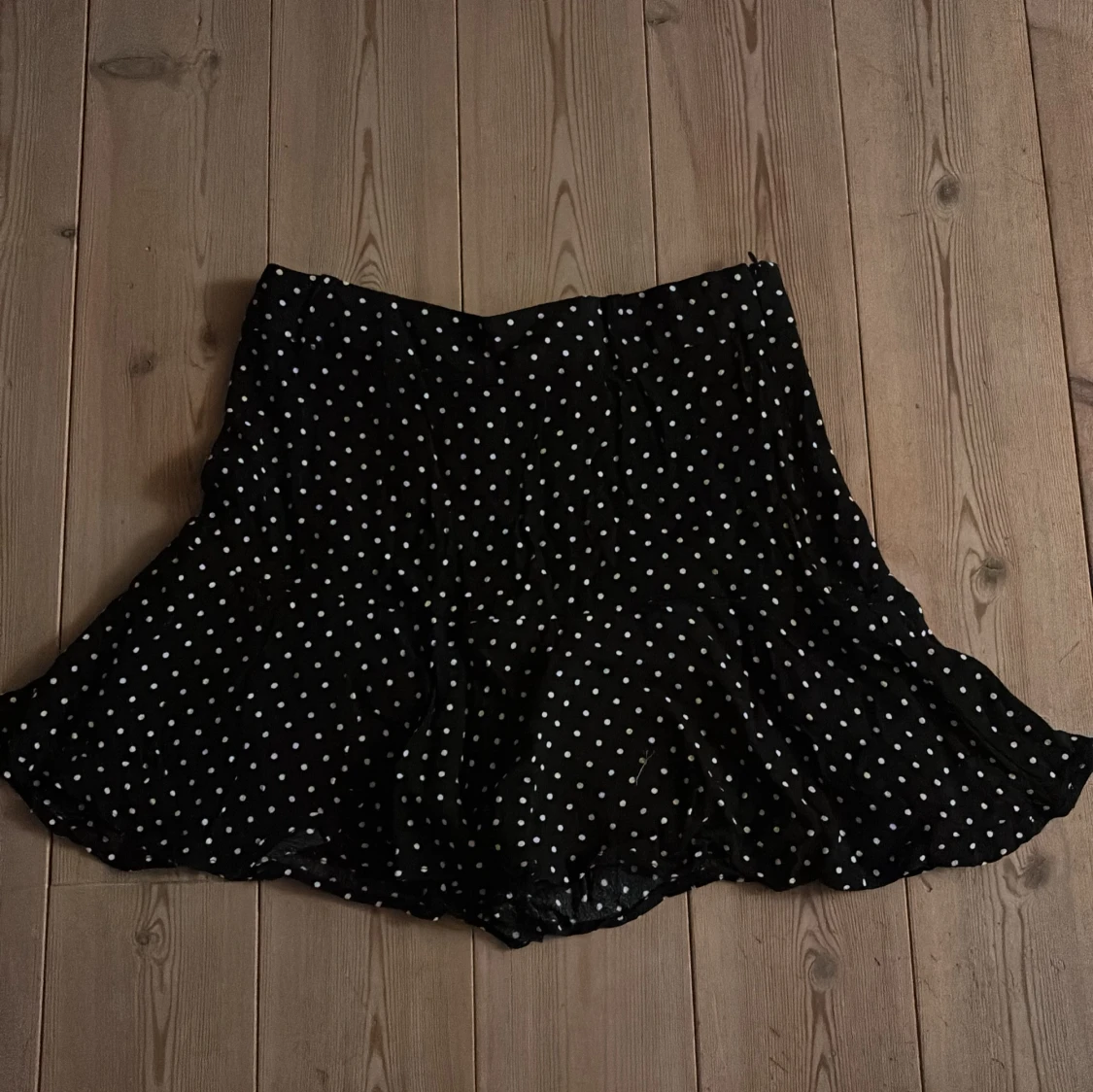 Svart prickig kortkjol med volang