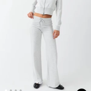 Slutsålda Gina Ljusgrå mjukisbyxor - Superbekväma ljusgrå mjukisbyxor med utsvängda ben och snörning i midjan. Byxorna har en loose passform och är tillverkade i mjukt bomullsmaterial. Perfekta för en chill och avslappnad stil. HELT SLUTSÅLDA. Obs dom har lite fläckar på baksidan längst ner på benen fråga om bild