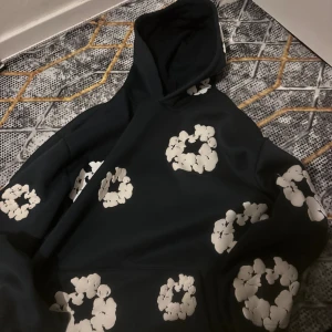 Denimen teirs  - Cool blå hoodie från denimin tears. med stora Märken har huva och är tillverkad i mjukt material, perfekt för att chilla eller hänga med kompisar. Oversized känsla och långärmad modell.