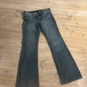 Blå bootcut jeans från H&M, strl 38 - Säljer ett par klassiska blå bootcut jeans från H&M i storlek 38. Jeansen har fem fickor, normal midja och är tillverkade i ett mjukt bomullsmaterial med lite stretch. Perfekta för dig som gillar en retro siluett med utsvängda ben.