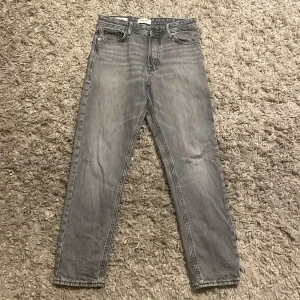 Grå jeans från Jack & Jones - Snygga grå jeans med raka ben och klassisk femficksdesign. Jeansen har en tvättad look och loose passform. Perfekta för dig som gillar en stilren och enkel vibe.