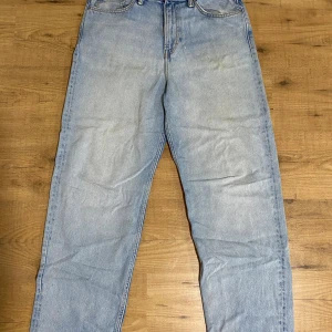 Ljusblå loose fit jeans från H&M - Säljer ett par ljusblå loose fit jeans från H&M i klassisk femficksmodell. Jeansen har raka ben och en avslappnad passform, perfekta för en chill och trendig look. Tillverkade i bomull och har en snygg tvättad finish.