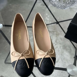Chanel ballerinaskor - Snygga ballerinaskor i beige skinn med svart tå och rundad form. Dekorativ rosett framtill och klassisk Chanel-logga på tån. Perfekt för dig som gillar stilrena och lyxiga detaljer. Oanvända och kommer med originalbox.💋🩰